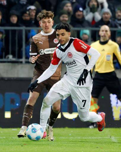 El delantero egipcio del Eintracht Fráncfort Omar Marmoush (derecha) pugna por el balón durante el partido de la Bundesliga contra el St Pauli, en Hamburgo, el 11 de enero de 2025