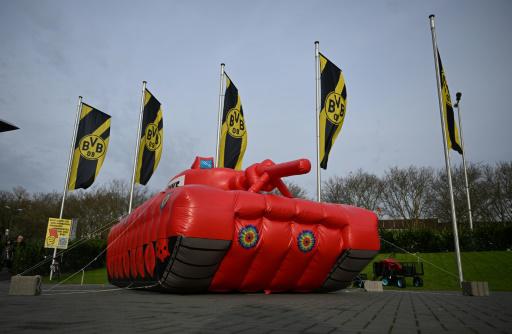 Una maqueta inflable de un tanque se muestra rodeada de banderas del Borussia Dortmund, antes de la asamblea general del club en Dortmund, oeste de Alemania, el 24 de noviembre de 2024