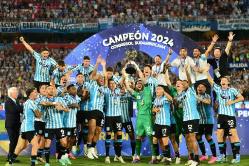 Racings's players celebrate with the trophy after winning the Copa Sudamericana final football match between Argentina's Racing and Brazil's Cruzeiro at La Nueva Olla Stadium in Asuncion on November 23, 2024.