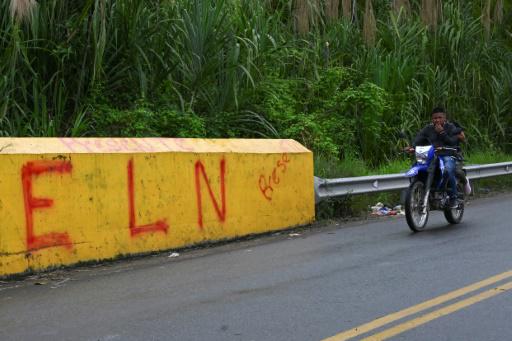 Un motociclista pasa por un muro en el que se lee ELN (Ejército de Liberación Nacional) el 6 de junio de 2024 en Corinto, Colombia