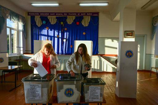 Dos mujeres depositan sus votos en las urnas de un colegio electoral del pueblo de Hirbovat, el 20 de octubre de 2024 en Moldavia