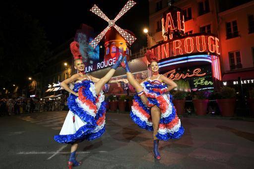 Dos bailadoras delante del cabaret Moulin Rouge de París durante la inauguración de sus nuevas aspas, el 5 de julio de 2024