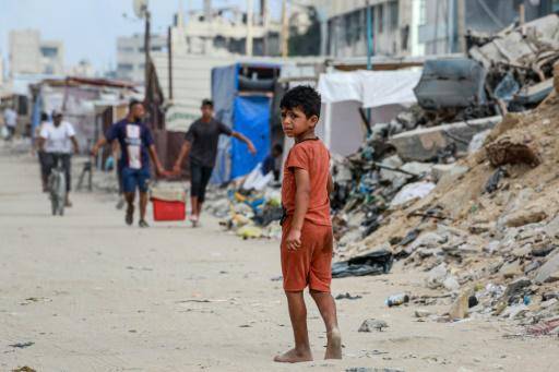 Un niño palestino camina con los pies descalzos en una calle en medio de desechos en Jan Yunis, en el sur de la Franja de Gaza, el 6 de julio de 2024