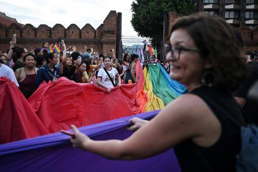 Una multitud participa en una marcha del Orgullo con una bandera del arcoíris en la ciudad de Chiang Mai, norte de Tailandia, el 26 de mayo de 2024