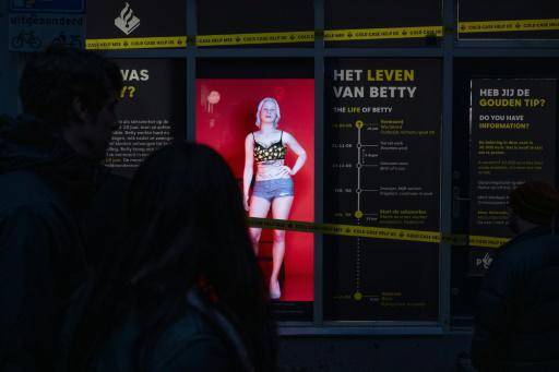 Unos peatones observan el holograma de la prostituta asesinada Bernadette Szabo, conocida como Betty, utilizado por la policía neerlandesa con el fin de recavar información, el 15 de noviembre de 2024 en Ámsterdam