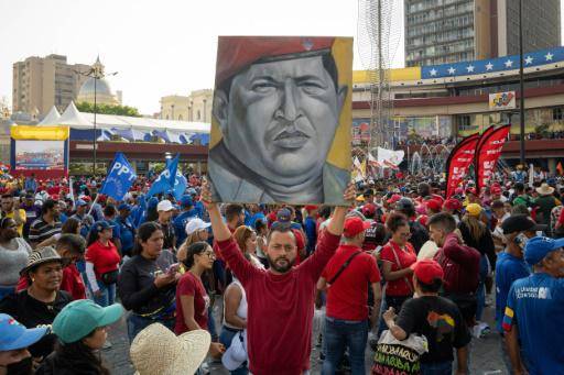 (ARCHIVO) Un simpatizante de Nicolas Maduro sostiene un cuadro con la imagen de Hugo Chavez delante del Consejo Nacional Electoral (CNE) el 25 de marzo de 2024.