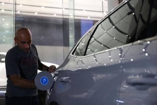 Un hombre inspecciona un coche eléctrico en una sala de exposición en Riad, el 8 de junio de 2024