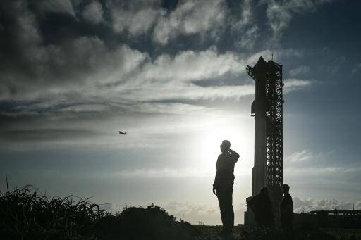 Un hombre observa un avión que vuela cerca de la nave espacial Starship de SpaceX, en la plataforma de lanzamiento, antes de su sexta prueba de vuelo desde Starbase en Boca Chica, Texas, el 17 de noviembre de 2024