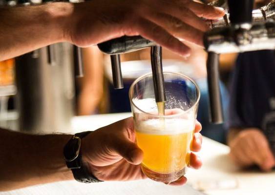 PIXABAY | Una persona sirviendo en un vaso cerveza artesanal para un grupo de amigos en un restaurante.
