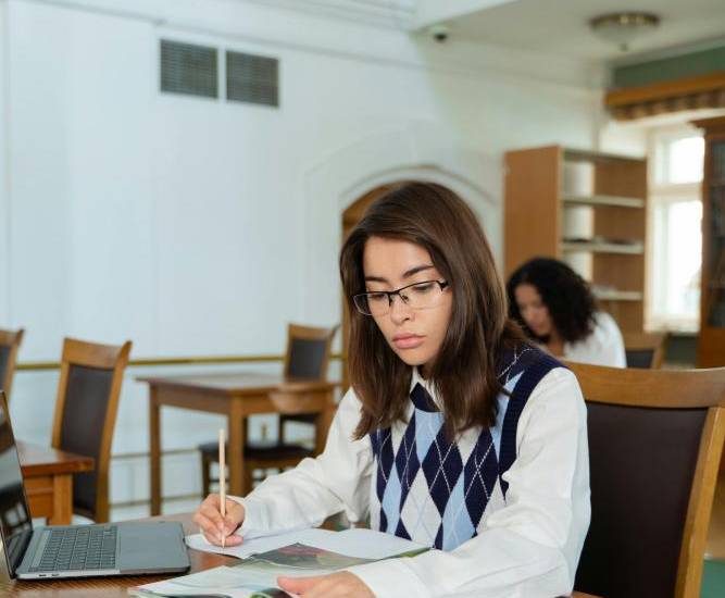 Pexels | Una chica estudiando en una biblioteca.