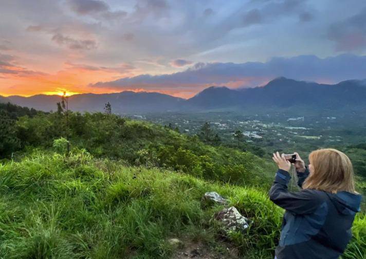 Ven al Valle | Una persona fotografiando el atardecer que se ve en el mirador Macano.