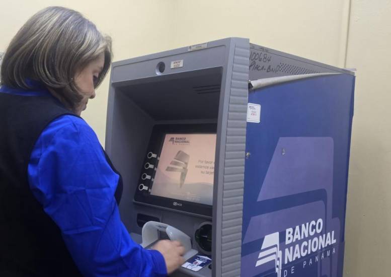 Una mujer retira dinero de un cajero del Banco Nacional.