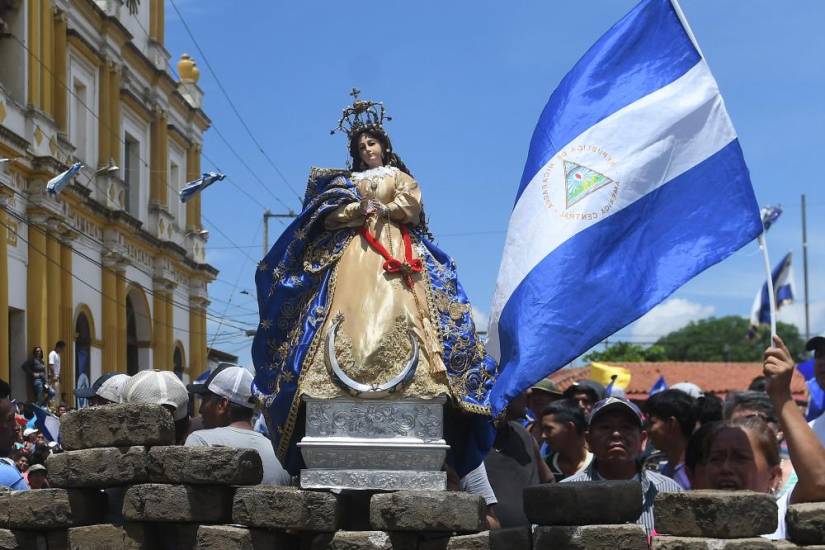 AFP | La gente celebra detrás de una barricada tras la llegada de obispos de la Conferencia Episcopal y miembros de la Alianza Cívica a Masaya, Nicaragua.