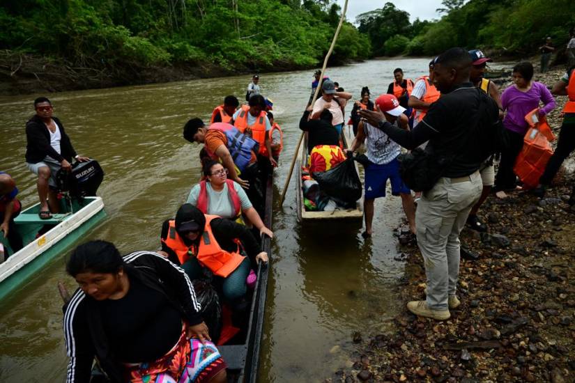 AFP | Migrantes se preparan para bajar del barco a su llegada al Centro de Recepción Temporal de Migrantes en Lajas Blancas, en la selvática provincia de Darién.