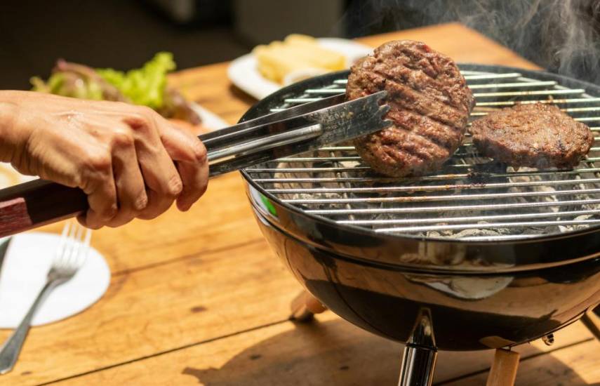 Pexels | Persona asando una carne a la parrilla, mientras el olor ahumado llena el ambiente.