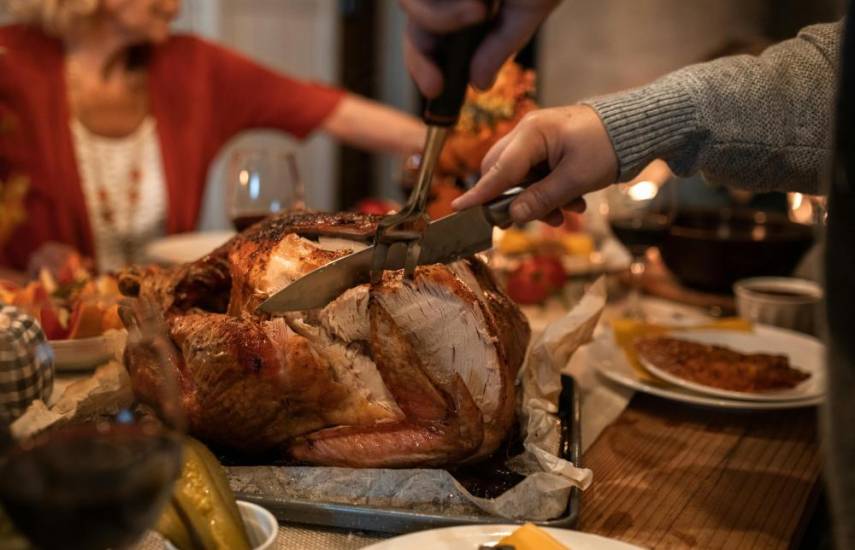 Pexels | Una persona procede a filetear el pavo durante la cena de Navidad, para servir a los demás comensales que se encuentran en la mesa.