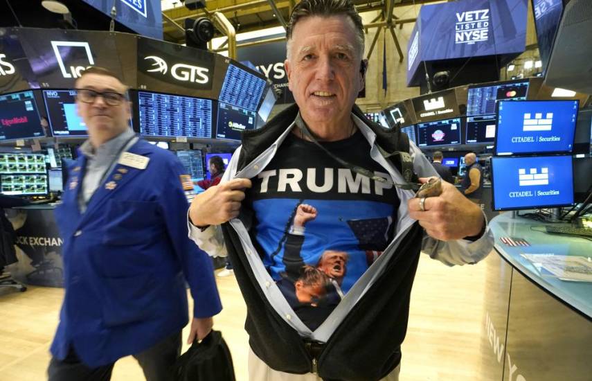 Trader Walter Lundon shows off his shirt featuring US President-elect Donald Trump, on the floor of the New York Stock Exchange (NYSE) in New York City on November 6, 2024. - Wall Street stocks surged in opening trading on Wall Street Wednesday after US voters sent Donald Trump back to the White House and delivered him a Republican Senate. Major indices were up 1.8 percent or more in the early going as hopes about expected tax cuts and regulatory easing more than offset worries about higher tariffs. (Photo by TIMOTHY A. CLARY / AFP)