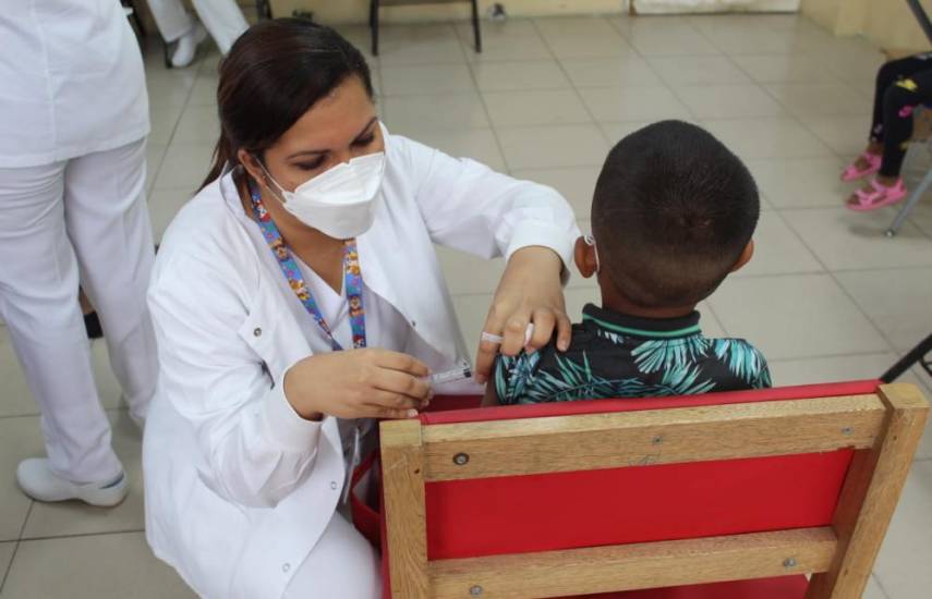 ML | Una enfermera colocando una vacuna a un niño.