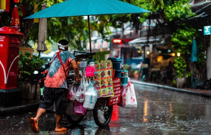 Pixabay | Un vendedor ambulante empuja su carro bajo de la lluvia.
