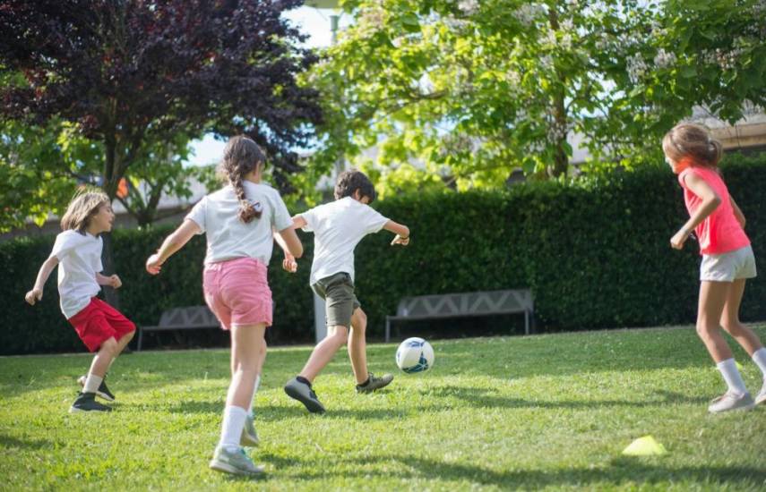 Pexels | Niños y niñas comparten un momento de diversión jugando fútbol al aire libre.