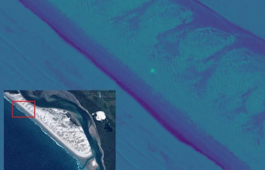 Mancha amarilla que indica plástico en la imagen satelital azul de una playa.