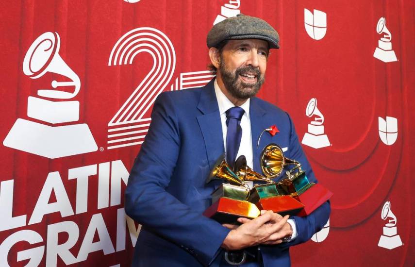 AFP | El cantautor dominicano Juan Luis Guerra sostiene sus premios.