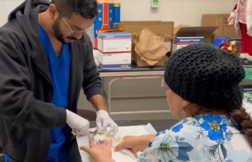 ML | Un doctor suturando los dedos de una adulta mayor.